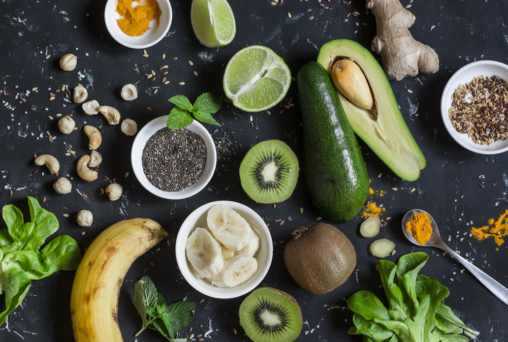 Green smoothie ingredients. Cooking healthy detox smoothies. On a dark background, top view